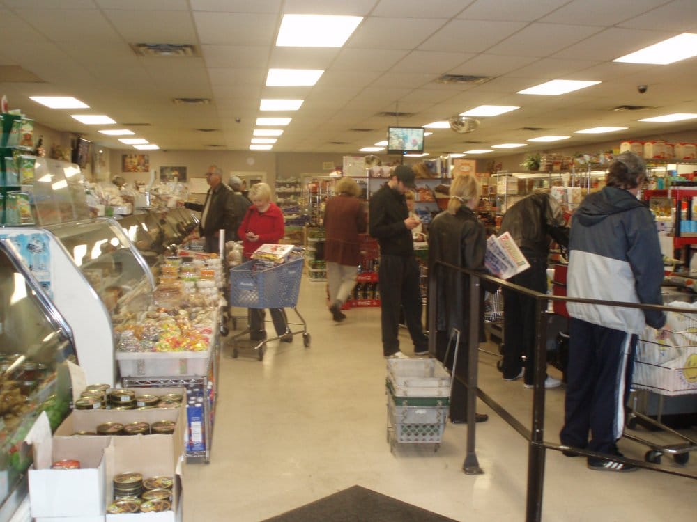 Inside International Food Market — the deli counter and shoppers in the aisles